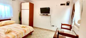 1 dormitorio con cama, mesa y TV en Dinka Apartment, en Trogir