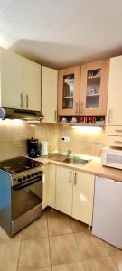cocina con armarios blancos y fogones en Dinka Apartment, en Trogir