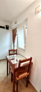 mesa de comedor con 2 sillas y ventana en Dinka Apartment, en Trogir
