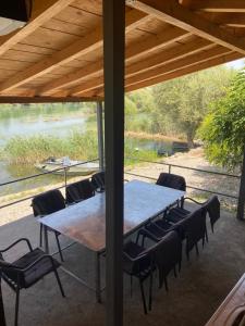 a table and chairs on a patio with a view of a river at Holiday home Ramovic in Virpazar
