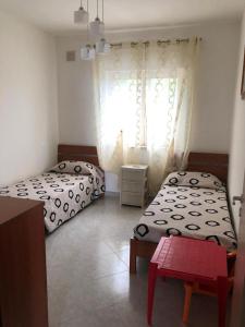 two beds in a room with a window at Apartment Napitia Hills in Pizzo
