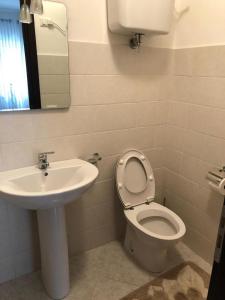 a bathroom with a sink and a toilet and a mirror at Apartment Napitia Hills in Pizzo