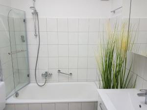 y baño blanco con ducha y bañera. en Eckernförde Baltic Beach, en Eckernförde