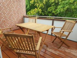 une table en bois et deux chaises sur une terrasse dans l'établissement Eckernförde Baltic Beach, à Eckernförde