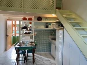 uma pequena cozinha com uma mesa e uma escada em Loft Armazém dentro da Vila Praia do Forte na Praia do Forte