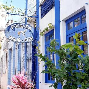 un panneau devant un bâtiment bleu et blanc dans l'établissement Pousada Beija Flor, à Salvador