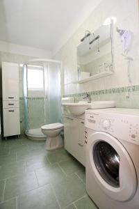 a bathroom with a washing machine and a sink at Apartments Ivana - Iva in Zadar