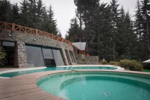 una piscina frente a una casa en Costa Serena Apart Cabañas & Spa en Villa La Angostura