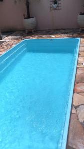 a large blue swimming pool in a yard at CASA PRIMAVERA- À 2 km do Thermas dos Laranjais in Olímpia