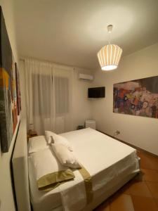 een slaapkamer met een groot wit bed en een licht bij Villa Sterlizia in Veglie