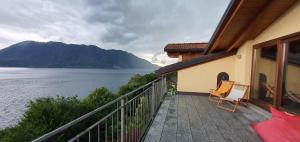 a balcony of a house with a view of the water at Bella Vista Lago Maggiore Einzigartiger Blick 365 Tagen in Ghiffa
