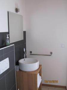 W łazience znajduje się biała umywalka i lustro. w obiekcie Ferienwohnung Schmid w mieście Hagnau