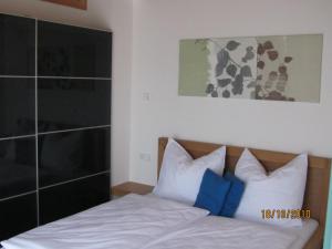 ハーグナウにあるFerienwohnung Schmidのベッドルーム1室(白と青の枕が備わるベッド1台付)