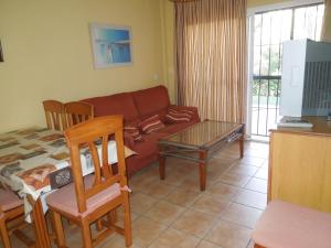 sala de estar con sofá y mesa en Residencial Golf Playa IV, en Islantilla