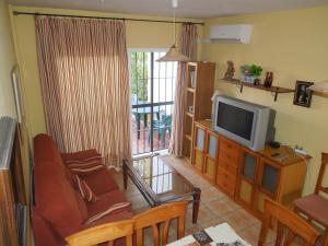 a living room with a couch and a tv at Residencial Golf Playa IV in Islantilla