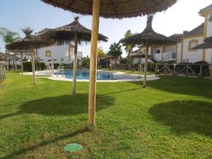 a group of umbrellas in the grass near a pool at Residencial Golf Playa IV in Islantilla