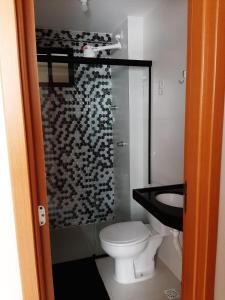 La salle de bains est pourvue de toilettes et d'une douche en verre. dans l'établissement Apto a 200metros da praia do Bessa!, à João Pessoa