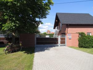 a driveway leading to a brick house with a gate at Ferienwohnung Smiley in Lübbenau