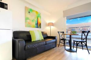 a living room with a leather couch and a table at Apartments 521 in Warrnambool
