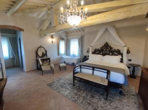 Un dormitorio con una cama grande y una lámpara de araña. en Villa Petriolo, en Cerreto Guidi