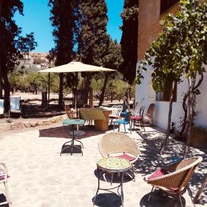 patio z krzesłami, stołami i parasolem w obiekcie La Villa di Minerva w mieście Agrigento