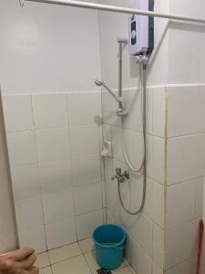 a bathroom with a shower with a blue bucket at CTUB Espana Manila in Manila