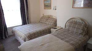 una habitación con dos camas y una ventana en Thalatta Guest House, en St Clements