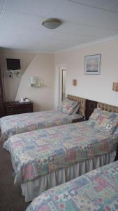 a hotel room with two beds and a television at Thalatta Guest House in St Clements