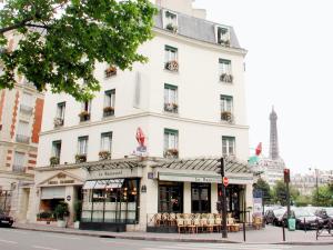 a white building with tables and chairs in front of it at Eiffel Kennedy in Paris