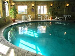 ein großer Pool mit blauem Wasser in einem Gebäude in der Unterkunft Sandringham Hotel - Seafront, Sandown in Sandown