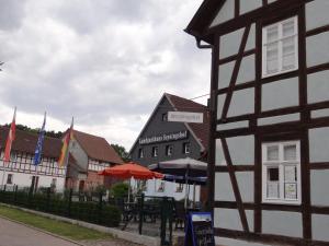 um edifício com um guarda-chuva e mesas à sua frente em Landgasthaus zum Seysingshof em Bad Colberg