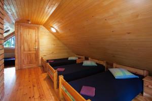 a room with three beds in a cabin at Atpūtas komplekss Godeļi in Usma