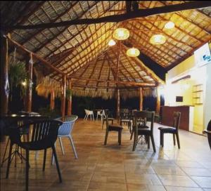 un restaurante con mesas y sillas bajo un techo de madera en Hotel Boutique Victoria, en Moyogalpa