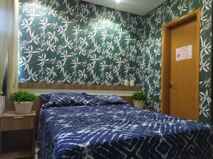 a bedroom with a bed with a blue and white patterned wall at Everest Flat Service - Apartamento 301 in Caldas Novas