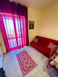 ein Wohnzimmer mit einem roten Sofa und einem Fenster in der Unterkunft Vacanzlucido in San Lucido