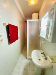 ein Badezimmer mit einem weißen Waschbecken und einem roten Handtuch in der Unterkunft Vacanzlucido in San Lucido