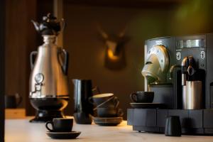 a coffee maker and cups sitting on a table at Mercure Auckland Queen Street in Auckland