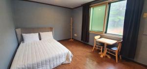 a bedroom with a bed and a desk and a window at Bigso Stay in Yangyang +17 photos