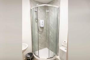 La salle de bains est pourvue d'une douche avec une porte en verre. dans l'établissement Sutton Contractor Accommodation - Warrington, St Helens, à Clock Face
