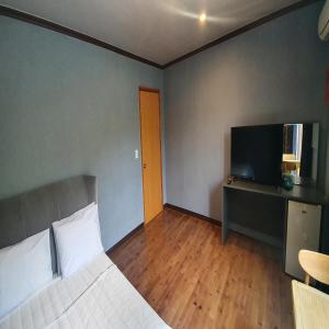 a bedroom with a bed and a flat screen tv at Bigso Stay in Yangyang