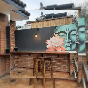 un bar con dos taburetes y una pintura de una flor en Depto.shanti-guemes Mar del Plata en Mar del Plata