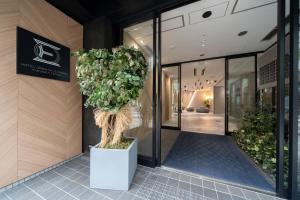 un gran árbol en la parte delantera de un edificio en Hotel Oriental Express Fukuoka Tenjin, en Fukuoka