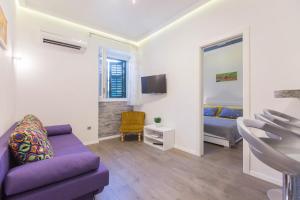 a living room with a purple couch and a bed at Centrino Apartment in Split