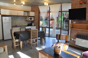 cocina y sala de estar con mesa y sillas en Cabañas Abril en Mar de las Pampas
