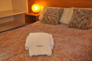 Una cama con una toalla blanca encima. en Cabañas Abril en Mar de las Pampas
