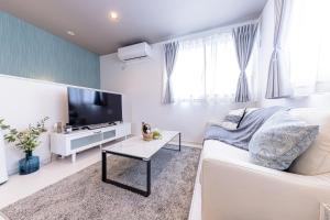 a living room with a white couch and a flat screen tv at ID STAY7 in Fujikawaguchiko