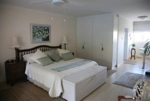 a bedroom with a large white bed and a window at Majorca House in Somerset West +31 photos