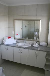 a bathroom with a sink and a mirror at Majorca House in Somerset West