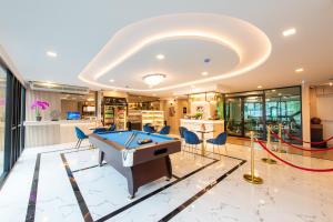 a pool table in a living room with a ceiling at Metro Hotel Ratchada 36 in Bangkok
