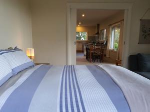 a bedroom with a large bed and a dining room at Mallavale Farm, Boat Harbour in Boat Harbour